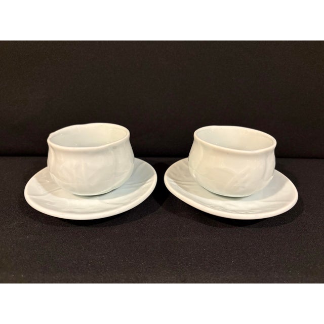 Elegant, minimalist light celadon porcelain cup and saucer service for two. Design features four botanical designs...