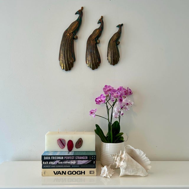 Carved, wooden peacock trio painted in a rich distressed teal. Wing and feathers wrapped in a thin layer of brass....