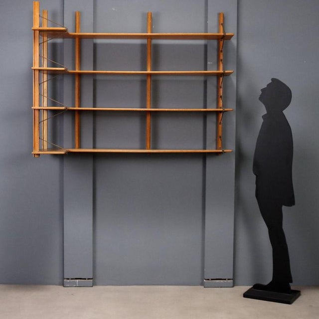 Italian-made corner wall-mounted bookshelf from the 1960s, featuring a functional and refined design. The wooden shelves...