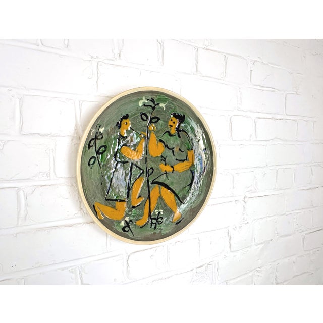 Large ceramic dish designed by Karl Niemann for Kähler in Denmark, dated 1954. The dish features a hand-painted figurative...