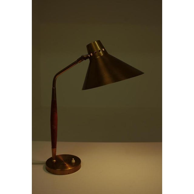 Swedish mid century table lamp model 8458 by Boréns, Sweden. The design features a slender brass stem with a tapered teak...