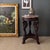 This Empire-style side table features a pink marble top and three legs carved into the shape of swans. The table base is a...