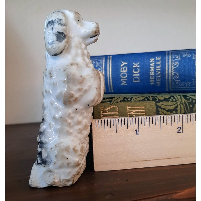 This adorable, very old Staffordshire poodle dog is standing on its hind legs, making it a delightful antique piece that...