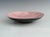 Pink glazed Roselane pottery bowl with free form swirl and Fish Design in black . Exterior of bowl in matte black finish...
