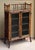A handsome English bamboo bookcase cabinet from the Aesthetic Movement period, featuring a decorative gallery top of...