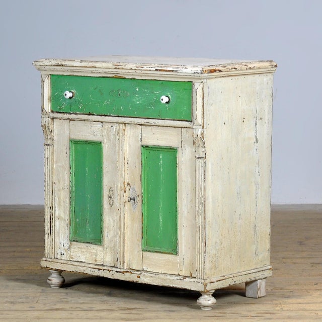 Pine dresser from around 1910 in the original paint. The cabinet has a well-functioning lock with key. Behind the doors a...