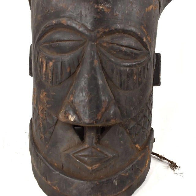 An exquisite Kuba Helmet Mask from Congo, made from wood and fibers, stands 17 inches tall. The Kuba people, who are...
