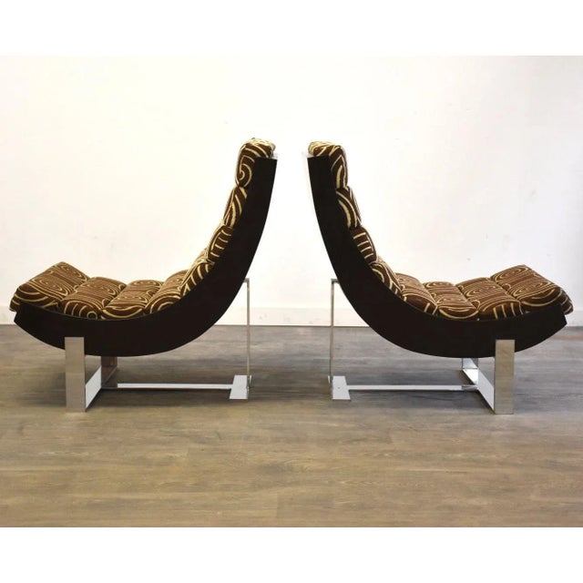 A pair of mid century modern chrome base lounge chairs with scoop seats and original fabric. Signs of wear to wood scoop....