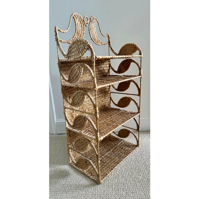 This Mario Lopez Torres small hanging wall etagere is crafted from hand-woven rattan and features distinct crescent moon...