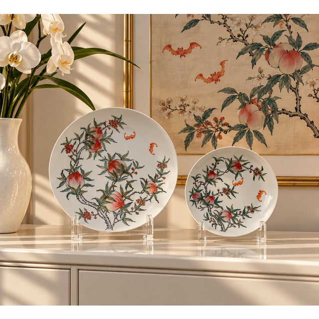 A vintage porcelain plate, hand-decorated with peach trees and fruit, and flying bats. Good condition.