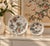 A vintage porcelain plate, hand-decorated with peach trees and fruit, and flying bats. Good condition.