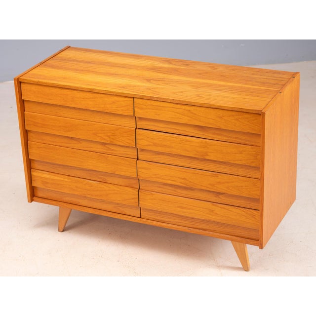 A classic vintage czech chest of drawers, model u-453, designed by jiří jiroutek in the 1960s. The cabinet features a warm...