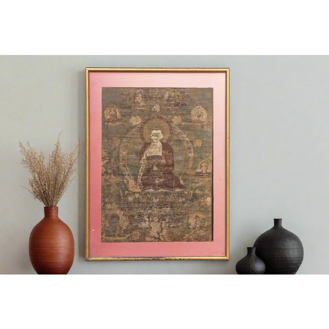 This antique Tibetan thangka, a captivating depiction of a serene Buddha, invites contemplation and reverence. The central...