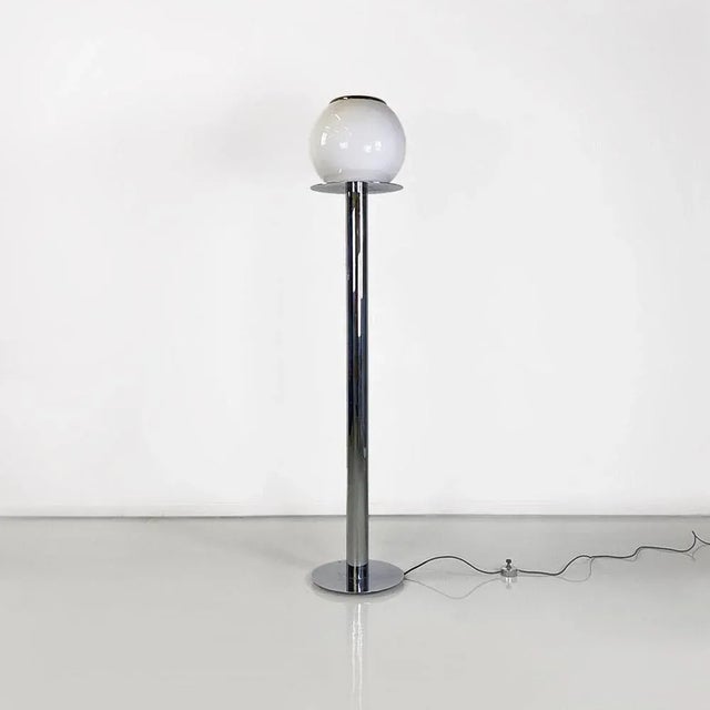 Floor lamp with chrome-plated steel frame, with a flat round base, mirrored at the top on which a spherical opaline glass...