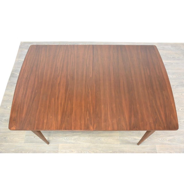 A mid century modern walnut dining table made by Broyhill. Professionally refinished. 60.25” wide. 40” deep. 29” tall.