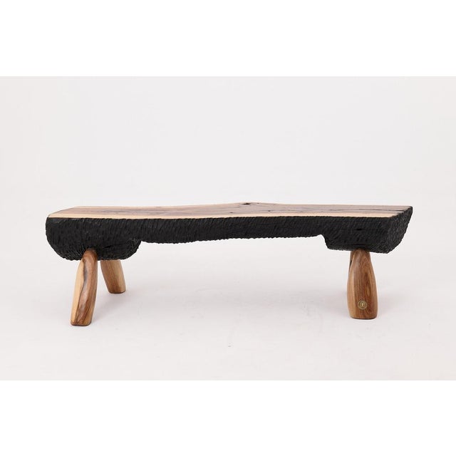 This sculptural bench is a one-of-a-kind work of functional art, handcrafted from a single solid hardwood slab and charred...