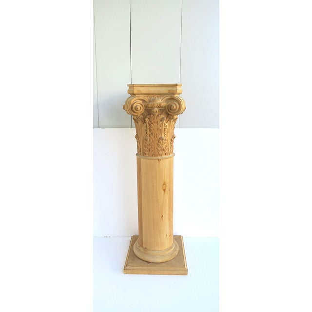 A substantial solid oak column pedestal stand with carved Corinthian capital, in the Greco‑Roman style, circa late‑20th...