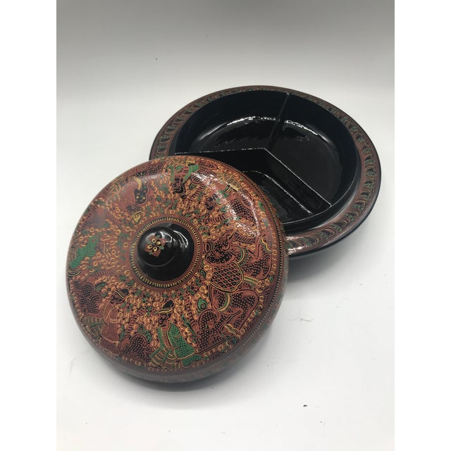 A finely engraved Burmese lacquer covered dish, likely a lahpet-ok, traditionally used to present fermented tea leaves and...