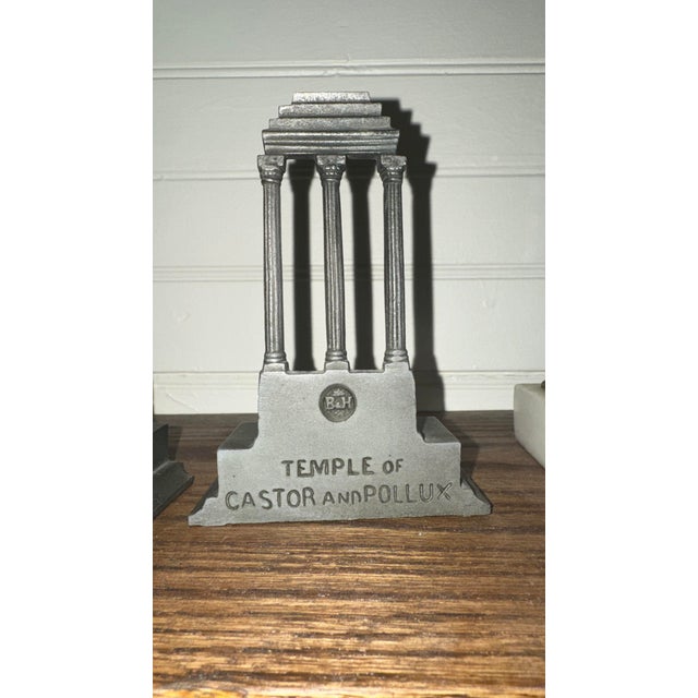 A pair of antique cast iron bookends by Bradley & Hubbard depicting the ruins of the Temple of Castor and Pollux. One side...