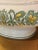 Elegant vintage covered soup tureen featuring a romantic green and golden yellow floral motif on a creamy white ground....