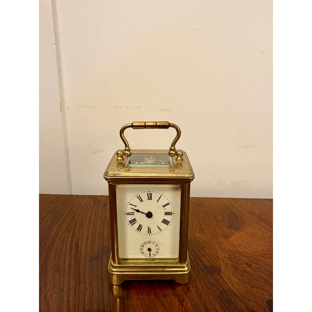 A charming antique Victorian miniature brass carriage clock with alarm, housed in a traditional gilt brass case with...