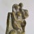 Expressionist bronze sculpture of a standing couple with child framed by a rectangular wall. The composition of the...