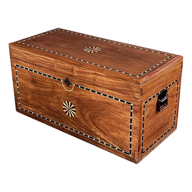 the hinged rectangular lid resting on a conforming body flanked by wrought iron handles; adorned on all sides with an...