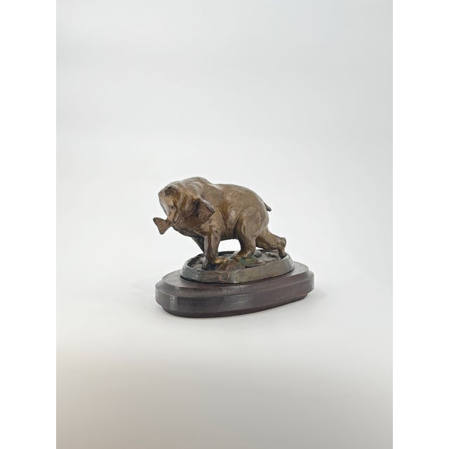 Snack Time is a charming bronze sculpture that captures a playful moment in the wild—a bear proudly clutching his catch, a...