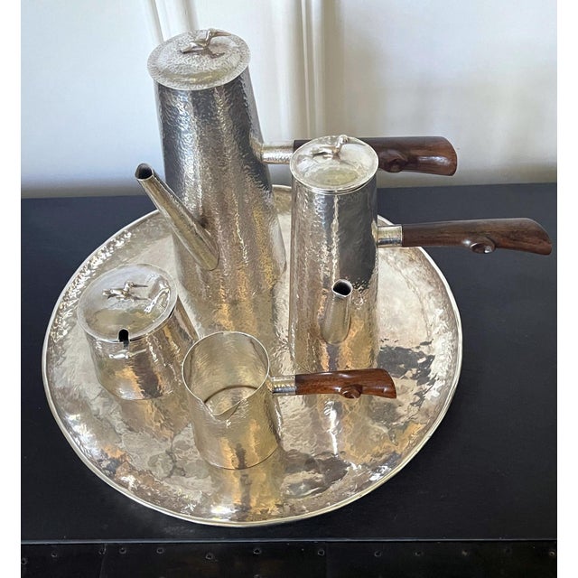 A sterling silver coffee service set consists of six pieces: a coffee pot, a chocolate pot, a covered sugar bowl with a...