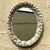 This vintage coastal oval mirror is beautifully encrusted with a variety of natural seashells, creating a textured, beach-...