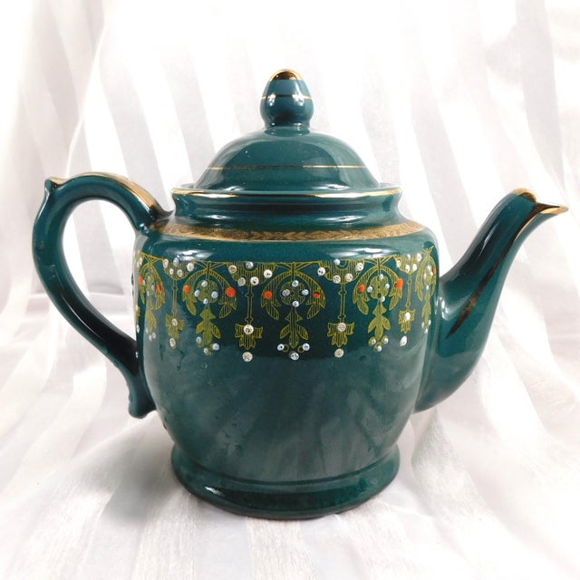 This is an unmarked dark teal teapot that is a working teapot that has a music box in the base. I am not sure what song...