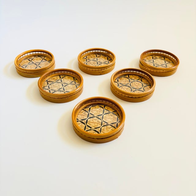 A vintage wicker coaster set. The set includes 6 coasters in a matching holder. Lovely woven interiors with acrylic bases...
