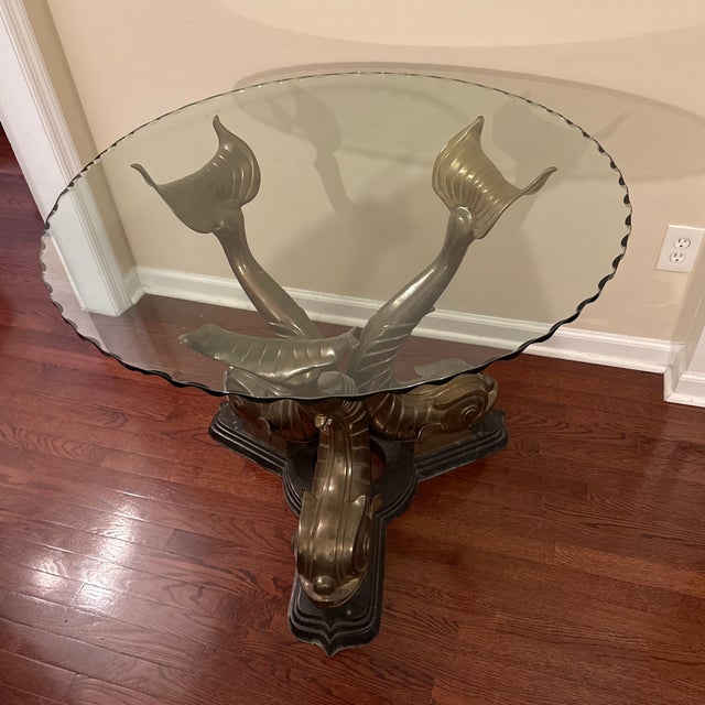 Three stylized brass dolphins form the base of this 1970s center or dining table from Italy. Hollywood Regency style at...