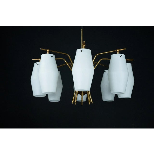 This elegant mid-century chandelier features eight angular opaline glass shades arranged in a sophisticated radial...