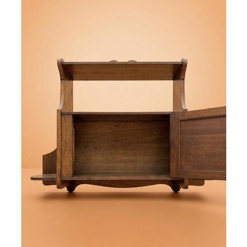 A charming Edwardian Arts and Crafts oak hanging wall cabinet, combining practical storage with decorative detail. The...