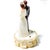 A beautiful vintage mid-century wedding cake topper featuring a classic bride and groom standing together on an ivory...