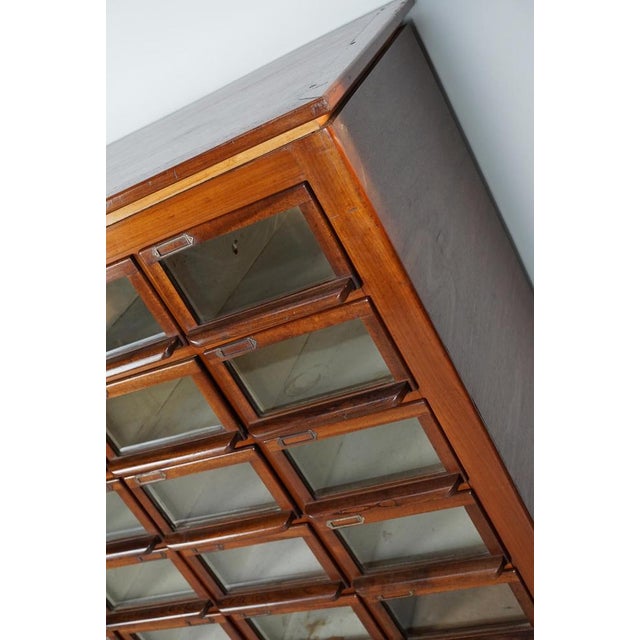 This haberdashery cabinet was produced during the 1930s in the Netherlands. This piece features 24 paper covered drawers...