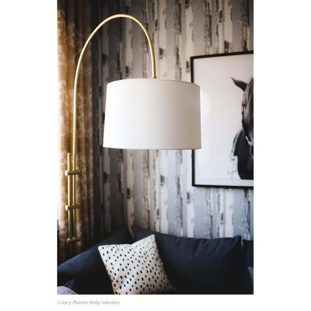 The juxtaposition of a metallic, adjustable base with a fabric shade gives this floor lamp a modern aesthetic—seamlessly...