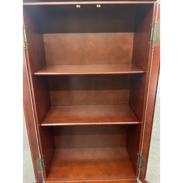 Bring the collected charm of an old-world library into your home with this tall apothecary-style display cabinet. A warm...