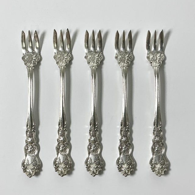 This set of six silverplated seafood forks are from the 1930-40s era. They feature a 3-prong fork and grape clusters with...