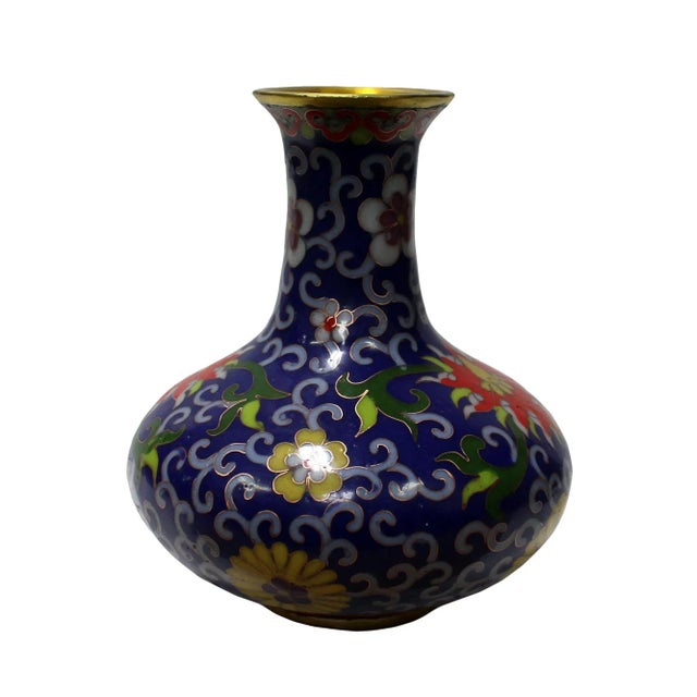 This is a traditional oriental Chinese vase made of metal and covered with purple blue enamel color. There is a floral...