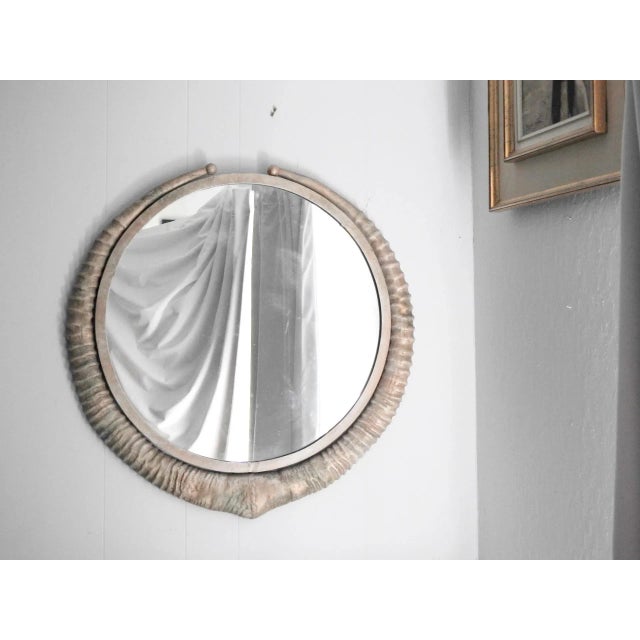 Tromp l'oeil metal wall mirror imitating antelope horns. Painted metal. Very heavy. Ready to hang. . Frame is 26"X27"....