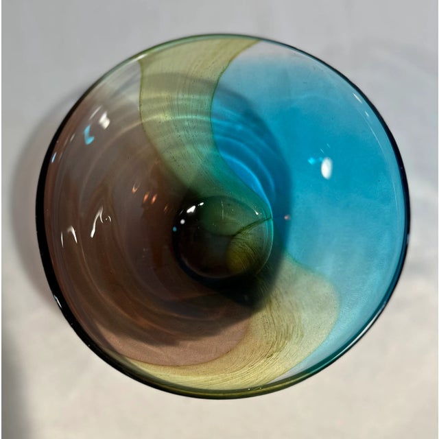 A vintage Murano art glass decorative bowl in a tri-colored swirl design in shades of cobalt blue, amethyst and clear with...