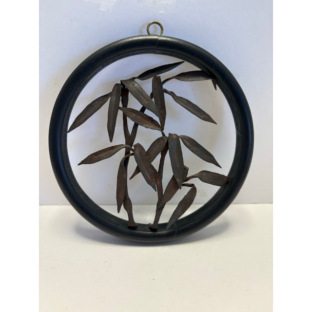 Charming set of two vintage metal botanical wall hangings featuring dimensional sculpted designs inside round black metal...