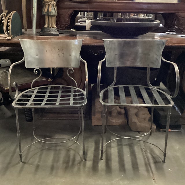 A near pair of sturdy steel Italian chairs from the late 20th century. This fabulous pair of chairs has a marvelous patina...