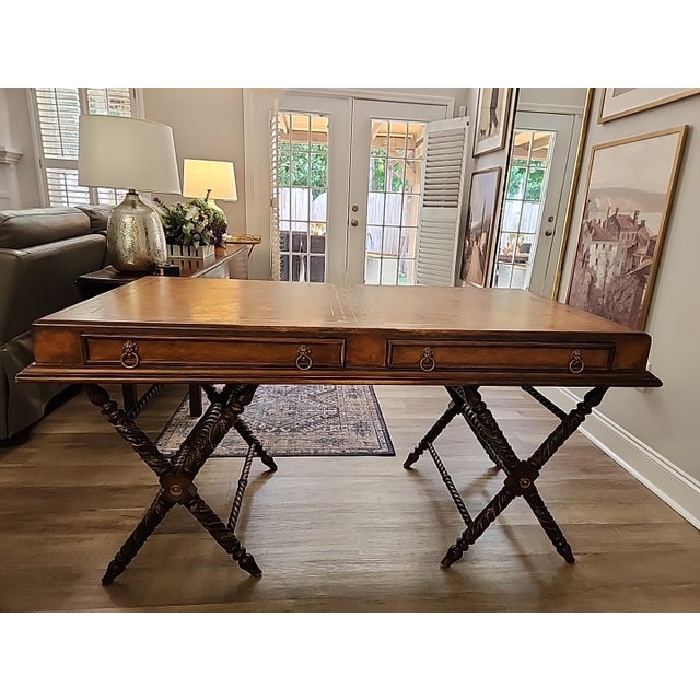 Vintage PTMC Recency-style writing desk featuring a warm brown fi ish and an unusual carved X-form trestle base with...