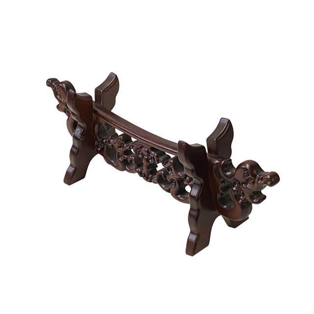 This is an oriental brush pen or sword holder made of wood with stained brown color on the surface. Dragon heads are the...