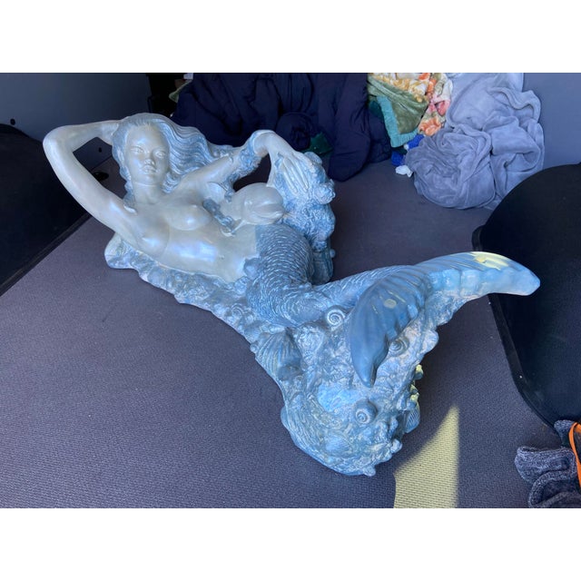 This vintage mid-century modern sculptural nude mermaid coffee table with a dolphin design exudes Hollywood Regency style....