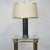 A 1950s brass and gold desk lamp. It features fabric shade with brass rim. This piece is attributed to the mentioned...