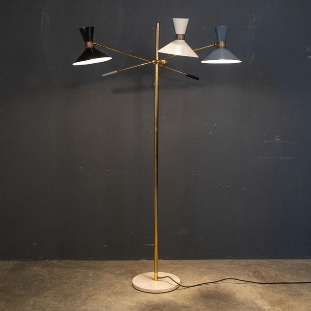 A stylish 20th Century Italian articulated standing lamp with three movable brass arms, brass body column and supported by...